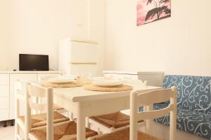 a white dining room with a white table and chairs at ModernShore - Oltremare in Tortoreto Lido