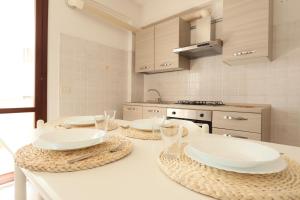 a kitchen with a table with plates and glasses on it at ModernShore - Oltremare in Tortoreto Lido