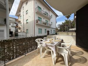a table and chairs on a patio with a building at ModernShore - Oltremare in Tortoreto Lido