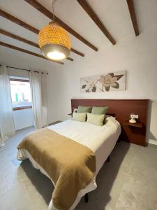 a bedroom with a large bed and a pendant light at Casa Tere in Teguise