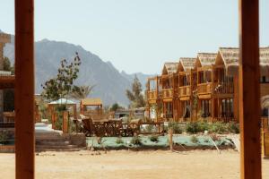 a building with a table and chairs in front of it at Green Beach Camp & Hotel in Nuweiba