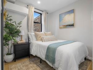 a white bedroom with a bed and a window at North End Apt close to TD Garden Walk to Downtown in Boston