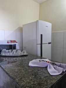 a kitchen with a counter with a refrigerator at Pousada Mar de Mamoã in Ilhéus
