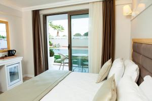 a bedroom with a bed and a balcony with a table at As Hotel Cesme in Çeşme +54 photos
