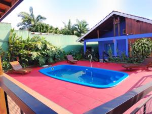 a pool on a patio with chairs and a house at Cabañas Posta Valentin in Puerto Iguazú