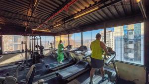 a man and a woman in a gym with machines at Sol Alphaville Hotel e Residence Flat in Barueri