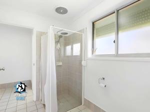 a white bathroom with a shower and a window at Coastal Charmer 3 Min Walk to Goolwa Beach in Goolwa South +14 photos
