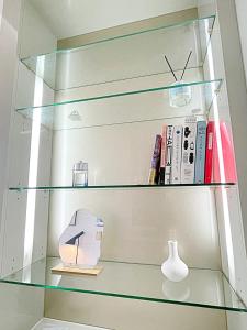 a glass shelf with books and a vase on it at 5sec from station, cosy house in Seoul