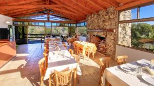 a dining room with tables and a stone fireplace at Cabañas Balcon al Champaqui in Villa General Belgrano