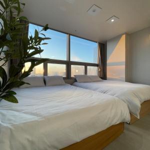 two beds in a bedroom with a large window at 5sec from station, cosy house in Seoul