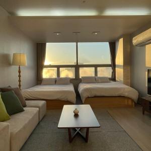 a living room with two beds and a couch at 5sec from station, cosy house in Seoul