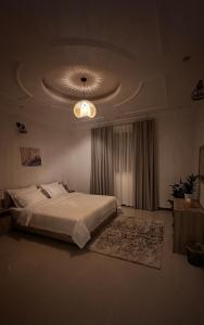 a bedroom with a large bed and a ceiling at شقة Noya غرفة وصاله بدخـول ذاتي in Taif