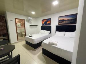 a hotel room with two beds and a bathroom at Hotel Penthouse in Bahía Solano +11 photos