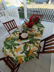 una mesa con un mantel con hojas en un patio en Résidence belle place, en Saint-François