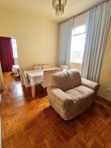 a living room with a couch and a table at Por do Sol nas alturas! Sua solução no centro de BH in Belo Horizonte