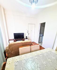 a bedroom with two beds and a television in it at Por do Sol nas alturas! Sua solução no centro de BH in Belo Horizonte