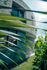 a building with green plants in front of it at Boho Jungle Villa - Pvt Pool -100mbs- Concierge 7A in Tulum
