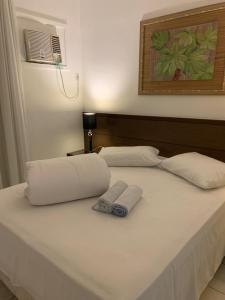 un lit blanc avec deux serviettes dessus dans l'établissement Porto Bali Resort - Apartamento em Angra dos Reis 6, à Angra dos Reis 23 autres photos