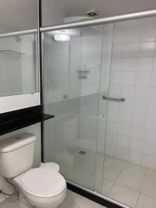 une salle de bain avec toilettes et douche en verre dans l'établissement Porto Bali Resort - Apartamento em Angra dos Reis 6, à Angra dos Reis