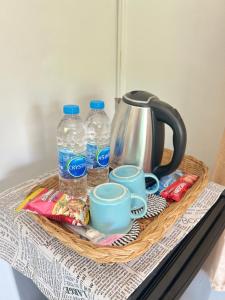 a basket with cups and water bottles on a table at บ้านต้นลมสุวรรณภูมิ Baantonlom suvarnabhumi in Ban Khlong Thewa +44 photos