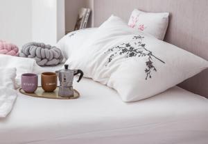 a bed with white pillows and two cups on it at Peaceful Stay Among the Vines in Vipolže +61 photos