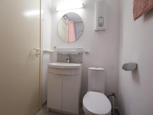 a bathroom with a toilet and a sink and a mirror at Studio by the Beach with Sea View in Oostduinkerke