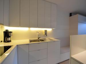 a kitchen with white cabinets and a sink at Studio in Belgium near Beach & Dunes in Oostduinkerke