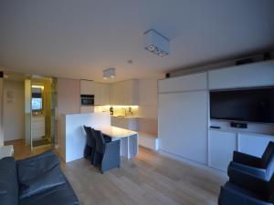 a living room with a table and chairs and a television at Studio in Belgium near Beach & Dunes in Oostduinkerke