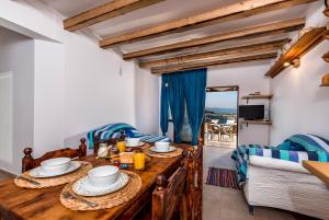 a dining room with a wooden table with food on it at Villa Lindos Muse in Lindos