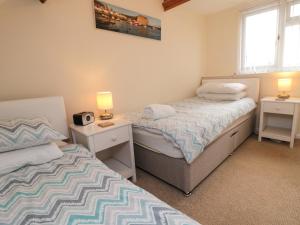 zwei Betten in einem kleinen Schlafzimmer mit zwei Lampen an in der Unterkunft Florence Cottage in Saltburn-by-the-Sea