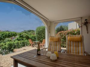 a patio with a table and two chairs and a view at Les jardins de Trevi in La Garonnette-Plage