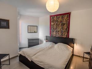 a bedroom with a bed and a table and a mirror at Les jardins de Trevi in La Garonnette-Plage