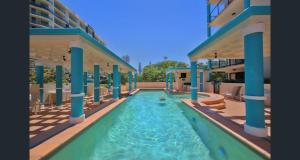 a swimming pool in the middle of a building at Stylish 1 Bedroom with Private Rooftop Spa at the Aegean in Mooloolaba