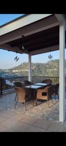 a table and chairs on a patio with a view of the ocean at ELDORA - LUXURY of LEISURE in Bhīm Tāl