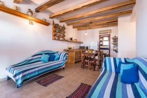 ein Wohnzimmer mit 2 Betten und einem Tisch in der Unterkunft Villa Lindos Muse in Lindos