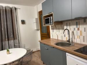 a kitchen with a sink and a table with chairs at Appartement 4 personnes Proche Centrex & Disneyland in Noisy-le-Grand