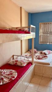 a room with three bunk beds with red sheets at Colônia de Férias Federação dos Papeleiros in Praia Grande