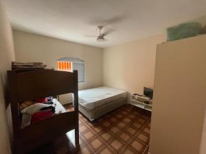 a bedroom with a bed and a room with a floor at Casa com Piscina Balneário Oásis - Quadriciclo in Peruíbe +12 photos