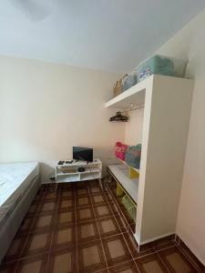 a small room with a bed and a desk at Casa com Piscina Balneário Oásis - Quadriciclo in Peruíbe