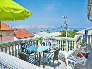 a patio with a table and chairs on a balcony at Apartment in Croatia near the Adriatic Coast in Senj
