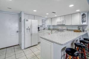 a kitchen with white cabinets and a white refrigerator at Striking Oceanview Condo in Fernandina Beach