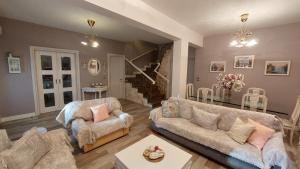 a living room with two couches and a staircase at Lux Center Apartment in Litochoro