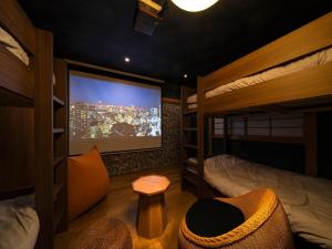 a room with a tv and a bed and a couch at Ryokan iriya in Tokyo