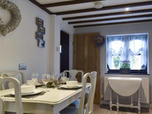 een eetkamer met een witte tafel en stoelen bij Wilma Cottage in Geldeston