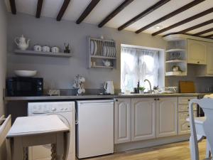 een keuken met witte kasten en een witte vaatwasser bij Wilma Cottage in Geldeston +13 foto's