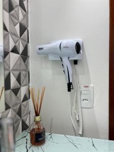 a hair dryer hanging on a wall in a room at Pousada Suíte Suzena in Penha