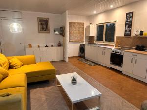 a living room with a yellow couch and a table at La maison d'à côté in La Tarodière