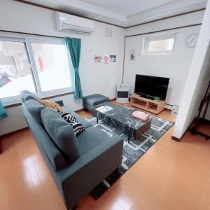 札幌市にある南12西9一戸建て Single Houseのソファとテレビのあるリビングルーム +20枚の写真