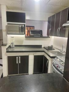 a kitchen with a microwave oven and a stove at Apartamento EURARE in Ríohacha
