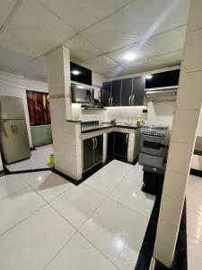 a kitchen with black and white cabinets and appliances at Apartamento EURARE in Ríohacha +9 photos